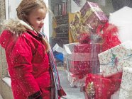 Mädchen bewundert Weihnachtsgeschenke im Schnee — Stockfoto