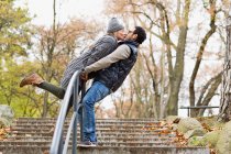 Casal beijando sobre trilhos parque — Fotografia de Stock