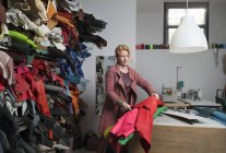 Frau trifft Auswahl aus Stapel von Lederfellen — Stockfoto