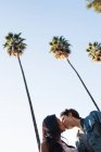 Junges Paar, das im Freien geht, küsst, Blick in den niedrigen Winkel — Stockfoto