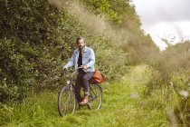 Портрет дорослого чоловіка на велосипеді на сільській дорозі — стокове фото