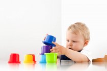Маленький хлопчик грає зі складанням чашок — стокове фото