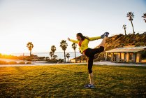 Donna che pratica yoga sul prato verde — Foto stock