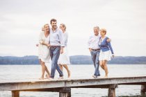 Group of friends standing walking along pier — Stock Photo