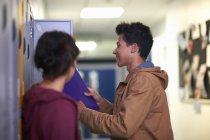 Young male student removing file from college locker — Stock Photo