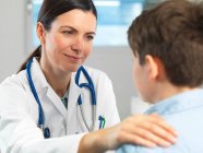 Доктор втішає молодого хлопчика в клініці — стокове фото