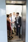 Médicos y empresarios en ascensor - foto de stock