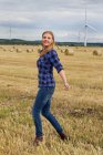 Young woman walking in harvested field — Stock Photo