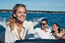Jovem mulher dirigindo barco com amigos no fundo, Gavle, Suécia — Fotografia de Stock