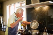 Homme plus âgé cuisine dans la cuisine — Photo de stock