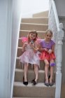 Girls in costume waiting on staircase — Stock Photo