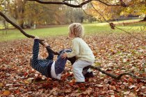 Хлопчики грають на дереві на відкритому повітрі — стокове фото