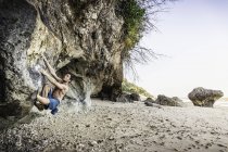 Escalador libre masculino escalando la cara de roca en Pandawa Beach, Bali, Indonesia - foto de stock