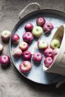 Apples falling from basket on tray, top view — Stock Photo
