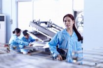 Tecnici che lavorano con attrezzature in fabbrica a LED nel Guangdong, Cina — Foto stock