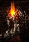 Blacksmith holding metal knife in furnace — Stock Photo