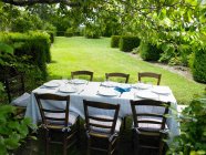 Набір столів в саду в яскравому сонячному світлі — стокове фото