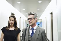 Коллеги по бизнесу идут по офисному коридору — стоковое фото