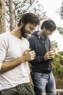 Two men drinking coffee in forest, Deer Park, Cape Town, South Africa — Stock Photo