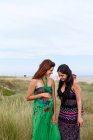 Беременная женщина и друг, стоящие в поле — стоковое фото