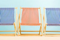 Three empty striped deckchairs, front view — Stock Photo