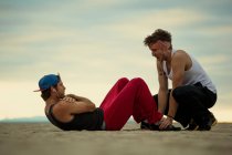 Männer trainieren gemeinsam am Strand — Stockfoto