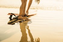 Молода жінка готує для серфінгу, La Jolla, Сан-Дієго, Каліфорнія, США — стокове фото