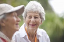 Two senior women chatting in retirement villa garden — Stock Photo