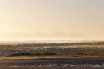 Sea with surf waves in sunset light — Stock Photo