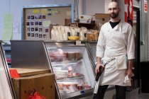 Butcher by counter of shop — Stock Photo
