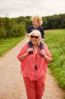 Grandmother carrying grandson on shoulders — Stock Photo