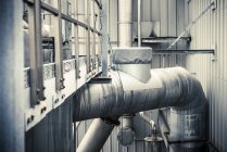 Detail of building exterior and piping at industrial plant — Stock Photo
