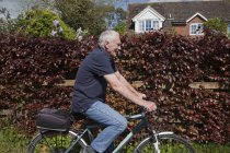 Senior man riding bike — Stock Photo