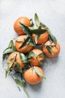 Top view of fresh tangerines with leaves on kitchen counter — Stock Photo