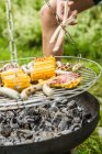 Close up partial view of young man barbecuing lunch — Stock Photo