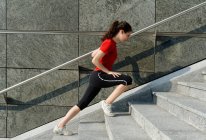 Mujer joven entrenando en escalera - foto de stock