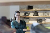 Portrait of proud female sales assistant in shoe shop — Stock Photo