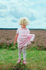 Девушка тянет платье в поле цветов — стоковое фото