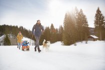 Parents pulling sons on toboggan in snow covered landscape, Elmau, Bavaria, Germany — Stock Photo
