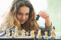Portrait of little girl playing chess — Stock Photo