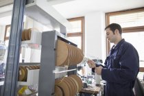 Elektriker zieht in Werkstatt Stromkabel aus Kabeltrommel — Stockfoto