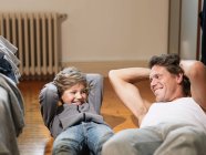 Mature man and son performing exercises in bedroom — Stock Photo