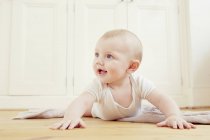 Sorridente bambino strisciare sul pavimento — Foto stock
