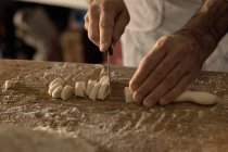 Обрізане зображення шеф-кухаря, що ріже тісто для нокаутів — стокове фото