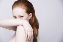 Portrait of young woman, side view, bare shoulders, looking at camera — Stock Photo