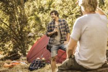 Männliche Camper plaudern und trinken Bier in Wald, Wildpark, Kapstadt, Südafrika — Stockfoto