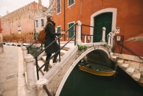 Frau überquert Brücke über Kanal, Venedig, Italien — Stockfoto
