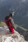 BASE jumper on mountain edge, Alleghe, Dolomitas, Italia - foto de stock