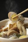 Chopsticks picking up egg from bowl of noodles — Stock Photo