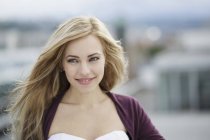 Beautiful long haired blond young woman in city — Stock Photo